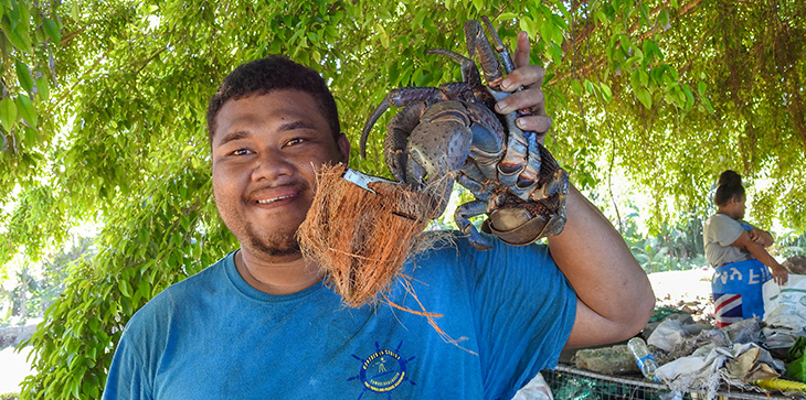 Leonard Loga, coconut crab hunter, feeding one of his catches before packing it,