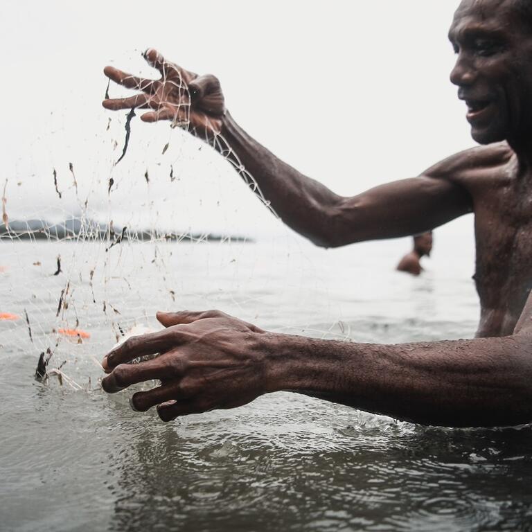 A man holding a fishing net in the water