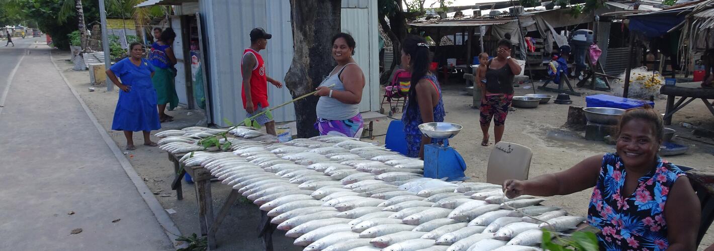 Women with fish on a table at a market in Kiribati