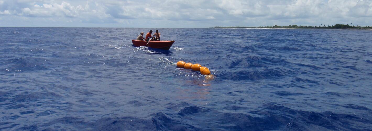 Men in a boat and orange buoys in the water